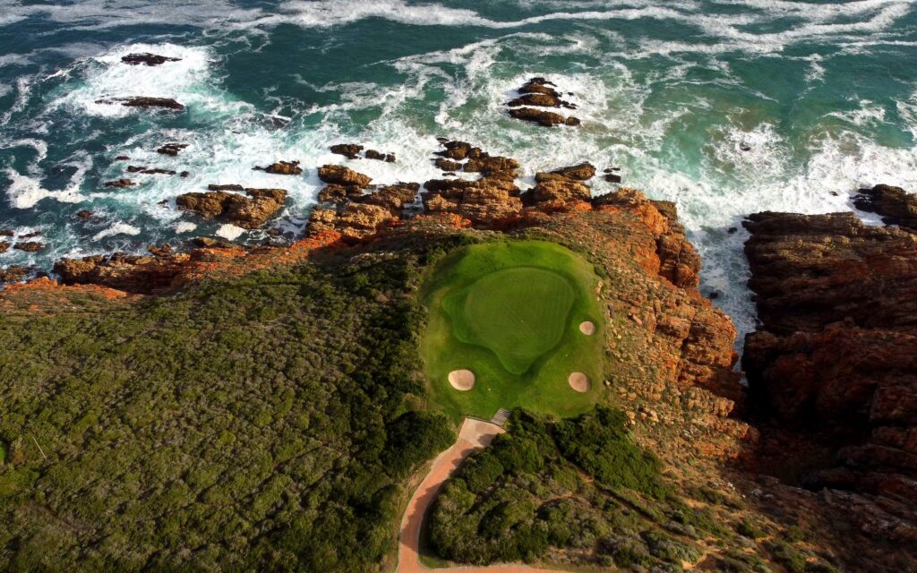 Pinnacle Point, Mossel Bay — Grün auf der Klippe über der Brandung, Drohnenaufnahme