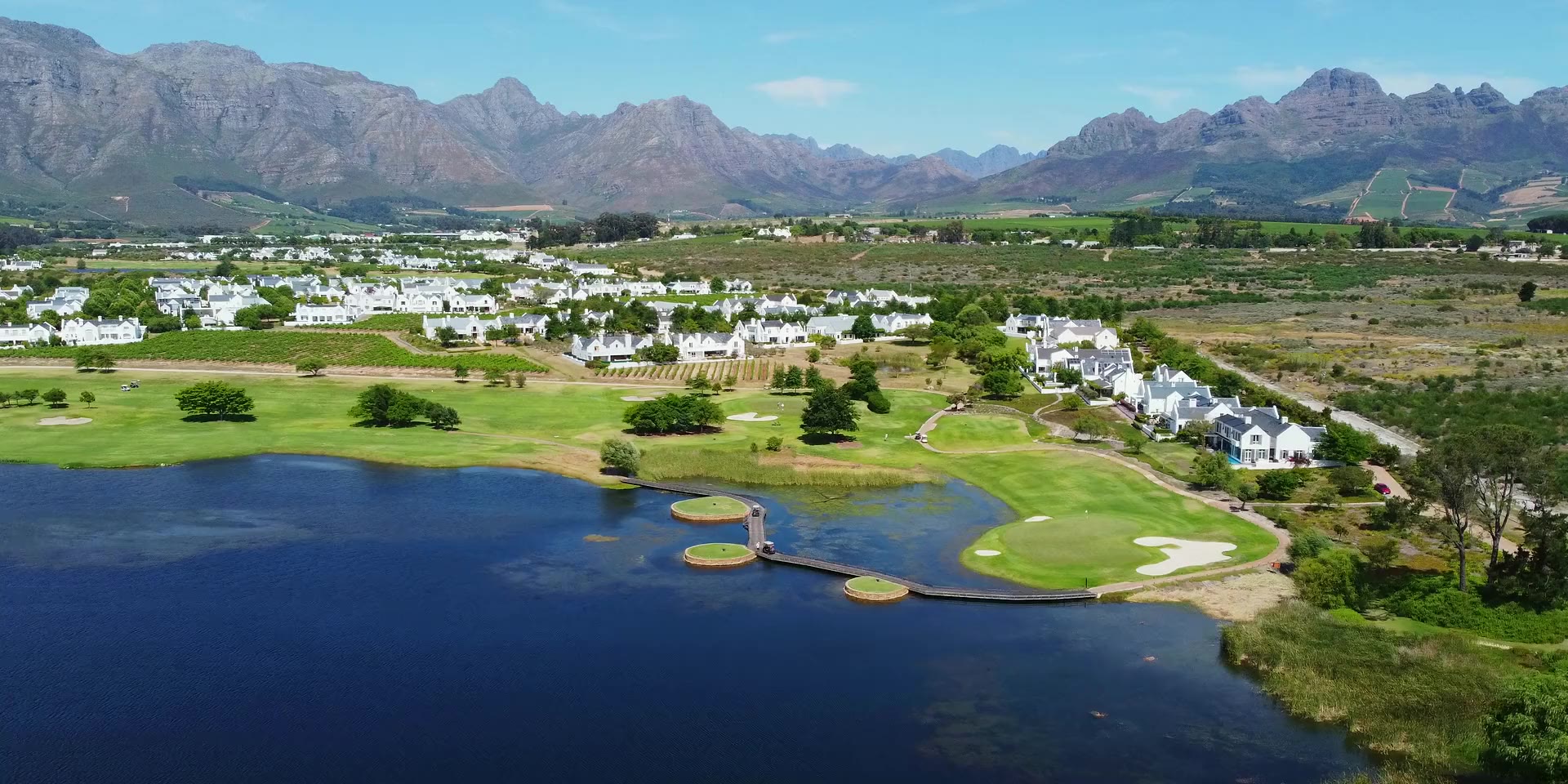 De Zalze bei Stellenbosch: See mit Inselabschlägen vor dem Bergpanorama